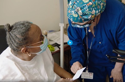 A Penn Medicine provider speaks with a patient after administering a COVID vaccine in her home.